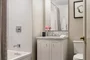 Luxuriate in master baths featuring white natural stone vanity, Kohler fixtures and accessories in polished chrome, and natural stone tile floor in white herringbone tile.