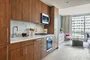 White quartz kitchen counter with a full-height Carrara marble tile backsplash