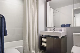 Custom bathrooms with polished natural stone floors, custom walnut vanities, and oversized showers