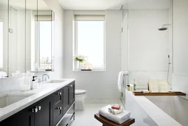 Custom walnut bathroom cabinetry with polished nickel hardware and imported Thassos polished marble countertop and floors, oversized marble showers and double vanities.