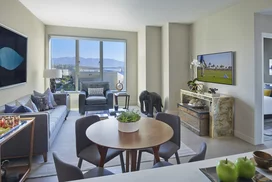 Aspire to culinary greatness in The Emerson's open kitchen with breakfast bar, featuring professional stainless steel appliances from Fisher & Paykel and Bosch, set against walnut cabinetry with Caesarstone counters and a full-height, tiled backsplash.