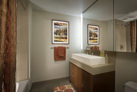 Bathrooms feature golden sandstone tile with arctic white corian vessel sinks.