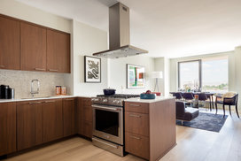 Masterfully appointed kitchens feature custom walnut kitchen cabinetry, polished quartz countertops, and Calacatta marble backsplash.