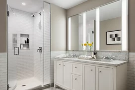 Luxuriate in master baths featuring white natural stone vanity, Kohler fixtures and accessories in polished chrome, and natural stone tile floor in white herringbone tile.