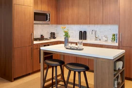 White quartz kitchen counter with a full-height Carrara marble tile backsplash