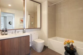 Luxurious bathrooms feature a walnut vanity, white quartz counters, and a mirrored medicine cabinet with integrated lighting