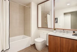 Luxurious bathrooms feature a walnut vanity, white quartz counters, and a mirrored medicine cabinet with integrated lighting