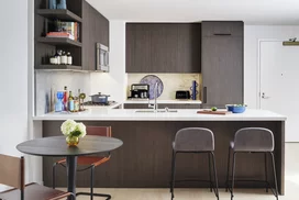 Open kitchens with custom grey-oak cabinetry, Bosch appliances, white Caesarstone counters and a Calacatta Caldia marble slab backsplash.