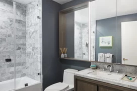 Luxe bathrooms include grey-oak vanities with marble counters, custom medicine cabinets and marble tub surround.