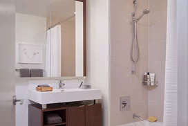 Custom bathrooms with polished natural stone floors, custom walnut vanities, and oversized showers.