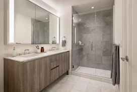 Well-appointed master bathrooms feature double vanities with Italian white marble, grey marble walls, and medicine cabinets with integrated lighting and pulls.