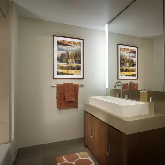 Bathrooms feature golden sandstone tile with arctic white corian vessel sinks.