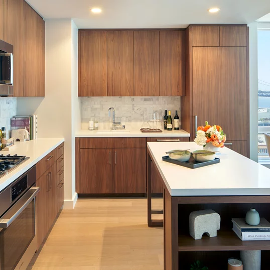 White quartz kitchen counter with a full-height Carrara marble tile backsplash